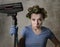 Maid service woman or upset housewife in hair rollers cleaning gloves with vacuum cleaner