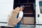 Mailman unloads the car with parcels, delivery