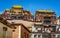 Main buildings of Ganden Sumtseling monastery colorful scenic view over clear blue sky Shangri-La Yunnan China