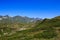 Main Caucasian Ridge and green grass alpine meadows with rhododendron