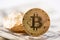 Main cryptocurrency golden bitcoin and gold lump represented on background of dollar banknotes