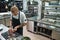 Main dish. Male bald chef with beautiful tattoos on his hands cutting a meat while standing in a restaurant kitchen