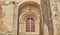 Main door of a catholic chapel with non original iron and wood veneer door