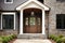 Main entrance door in house. Wooden front door with gabled porch and landing. Exterior of georgian style home cottage with white