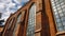 The main nave of the church in Gdansk with tall glass windows and brick style wall seen from the outside