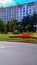 Main street of Zelenograd city with green lawns, colorful flowerbeds, trees and residential buildings.