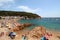 Main view of crowdy beach of Tamariu with village in background, Costa Brava, Catalonia, Spain