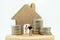 Mainature people standing with coins stack and home.  Home financial investment Concept