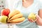 Maintaining Healthy Lifestyle. Chubby girl standing in kitchen with plate of fruits and vegetables close-up