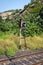 Maintenance engineer fixing the faulty railway light signal on a busy railway track