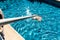 Maintenance man using a pool net leaf skimmer rake in summer to leave ready for bathing his pool