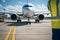 Maintenance supervisor approaches parked airliner on landing field, viewed from behind.