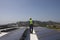 Maintenance Worker Inspecting Solar Panels On Rooftop
