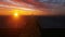 Maintenance Worker on Solar Panels Farm and Wind Turbines in the distance at Sunrise, 4K