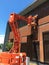 Maintenance Workers on Orange Cherry Picker Crane