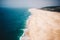 Majestic aerial view of a tropical crowded sandy beach and a beautiful blue seascape