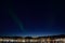 Majestic aurora borealis dancing on night sky over the arctic circle city of tromsoe