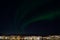 Majestic aurora borealis dancing on night sky over the arctic circle city of tromsoe