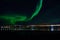 Majestic aurora borealis over fjord, mountain and bridge