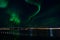 Majestic aurora borealis over fjord, mountain and bridge in the arctic circle