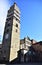 The majestic bell tower, next to the cathedral, illuminated by the sun in the blue sky in Pistoia. Pistoia is a city in Tuscany.