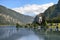 Majestic Buddha sculpture near lake and mountains on sunny day