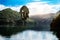 Majestic Buddha sculpture near lake and mountains on sunny day