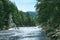 Majestic Buddha sculpture near wild mountain river in forest