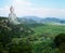 Majestic Buddha sculpture rising above picturesque mountains on sunny day