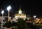 The majestic Buddhist temple in Bangkok at night. Street lights illuminate the small garden