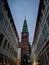 Majestic clock tower stands tall amidst a bustling city street in Copenhagen, Denmark.