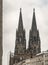 Majestic Cologne Cathedral Towers Rising Above Modern City Buildings on an Overcast Day