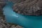 Majestic colorful turquoise blue river, red speed boat float with curved white path and waves on water among high steep mountain.