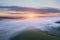 Majestic drone landscape image of sea of fog rolling across South Downs English countryside during Spring sunrise