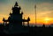 Majestic evening shot: Man poses holding Sun ball, ancient temple silhouette in foreground. Uttarakhand India