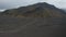 Majestic high angle view of icelandic panorama, with rocky mossy hill peak and car driving peacefully. Aerial view of