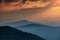 Majestic landscape of mountains at sunrise. View of the misty tops and layer hills of the mountains in the distance.