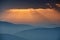 Majestic landscape of mountains at sunrise. View of the misty tops and layer hills of the mountains in the distance.