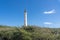 Majestic lighthouse on a hill surrounded by lush greenery