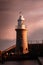 Majestic lighthouse towers at dusk with dark storm clouds