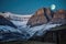 majestic mountain landscape with a full moon, casting its eerie glow over the rugged terrain