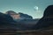 majestic mountain landscape with a full moon, casting its eerie glow over the rugged terrain