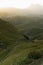 Majestic mountain landscape - high rock bizarre ridge and village in golden sunbeams of early morning sun, white soft mist