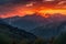 majestic mountain range, with fiery sunset and smokey skies