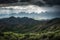 majestic mountain range, with a storm brewing in the distance