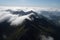 majestic mountain range viewed from above, with clouds obscuring part of the view