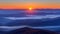 Majestic mountain sunrise paints clouds and fog in orange sky, creating stunning landscape view