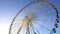 Majestic observation wheel rotating in amusement park, sunny blue sky background