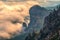 Majestic orange sunset over the rocky mountains and the valley in fog and clouds. Creamy fog covered the mountain valley in sunset