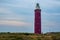 Majestic Red Lighthouse Standing in Coastal Landscape